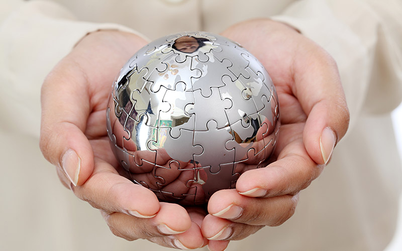 Hands holding a globe puzzle